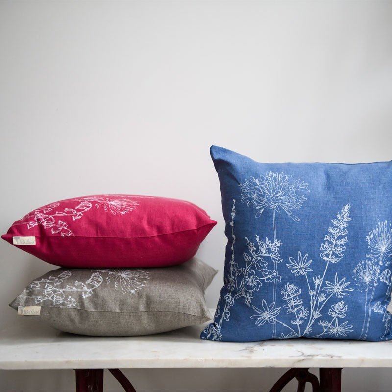 Three pure linen cushions from the Garden Collection in natural, raspberry red and indigo blue. Handprinted in white by Helen Round
