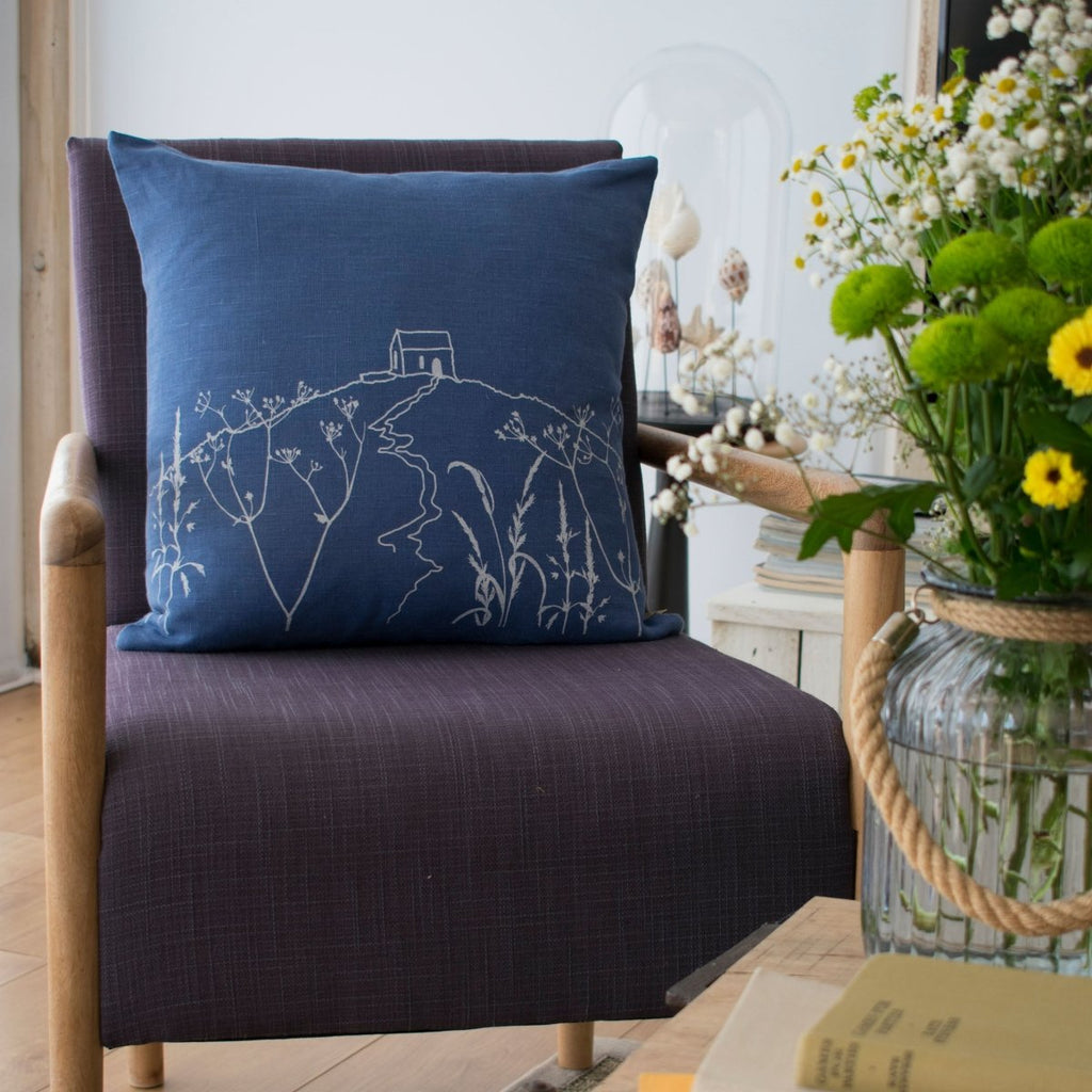 The coastal-inspired Indigo blue linen cushion features a hand printed design in white from The Rame Head Collection by Helen Round.
