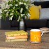 Rame Head Orange Mug in bone china on table with books and flowers from Helen Round