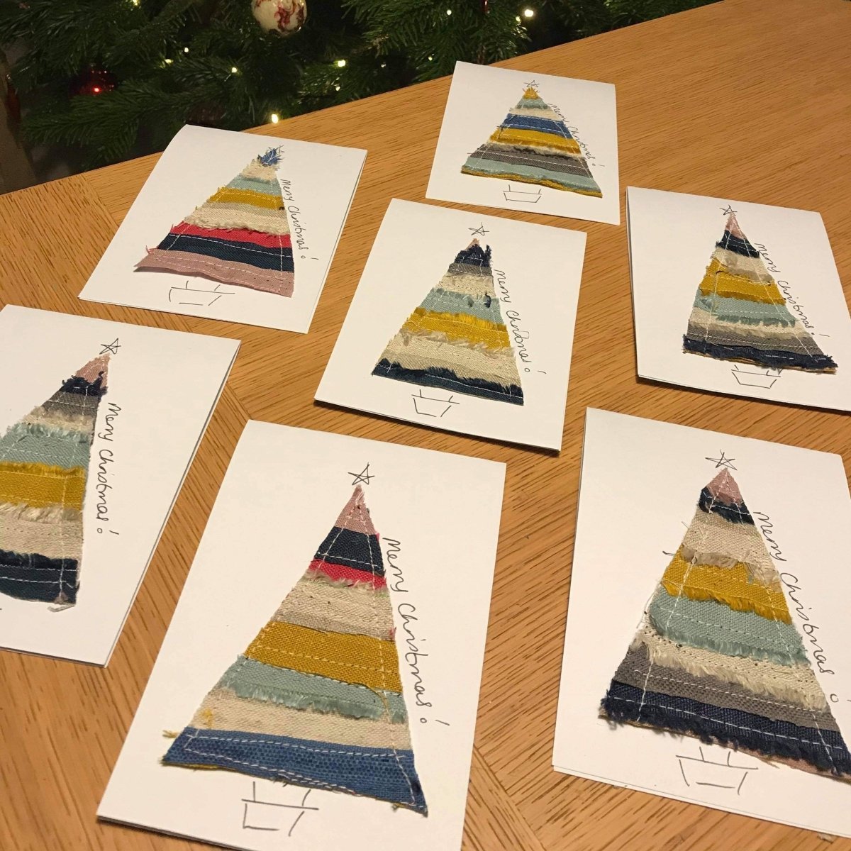 Handmade Christmas cards featuring Christmas trees sewn from colourful linen fabric scraps