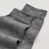 Grey merino wool socks on a light grey background