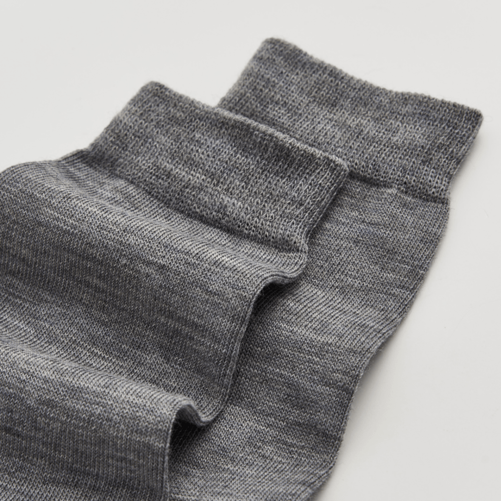 Grey merino wool socks on a light grey background