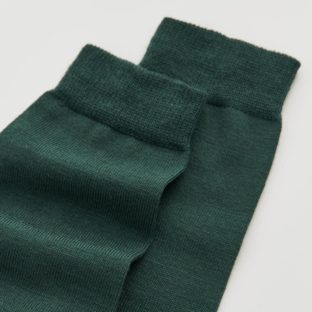 Pair of green socks on a light gray background