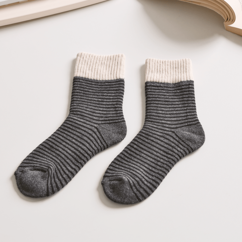 Pair of gray socks with white trim on a light surface