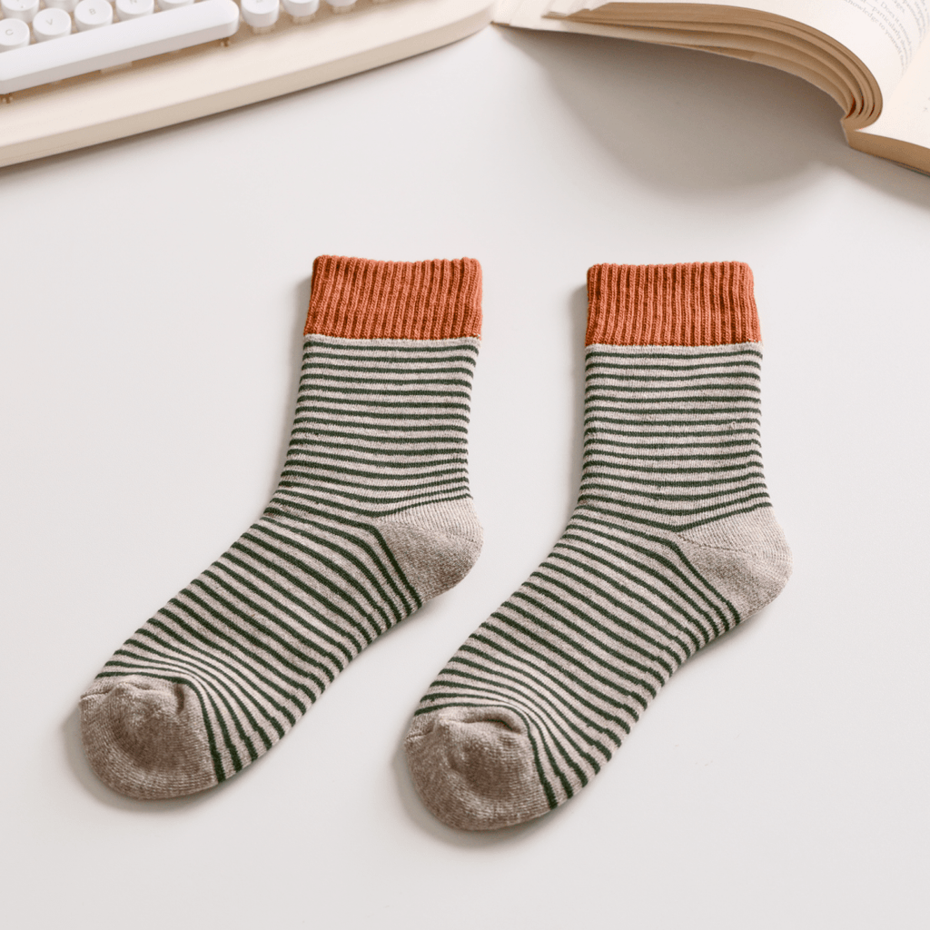 Pair of striped socks with orange tops on a light surface, next to a keyboard and book. Sold by Helen Round