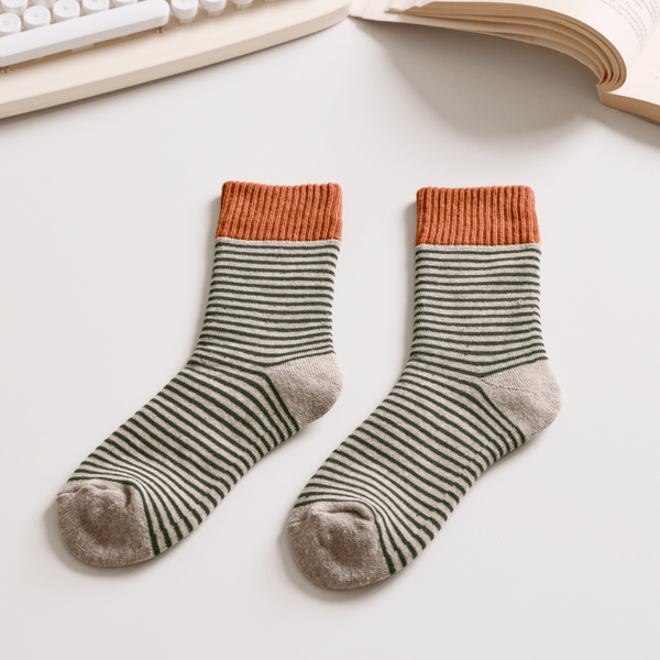 Pair of striped socks with orange tops on a light surface, next to a keyboard and book. Sold by Helen Round