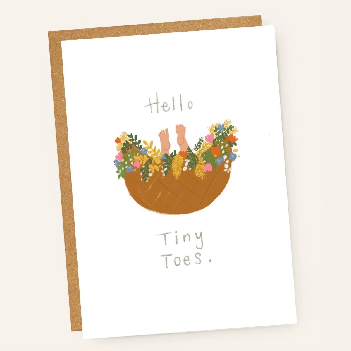 Greeting card with illustration of baby feet in a basket with flowers and text 'Hello Tiny Toes' on a beige background sold by Helen Round