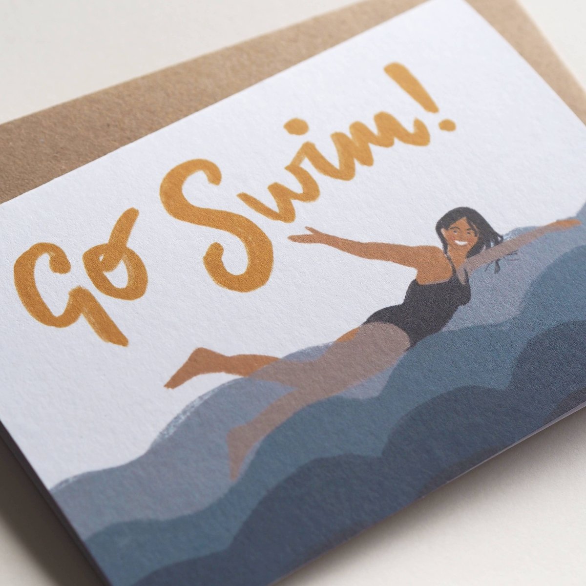 Greeting card with 'Go Swim!' text and a swimmer illustration on a white background sold by Helen Round