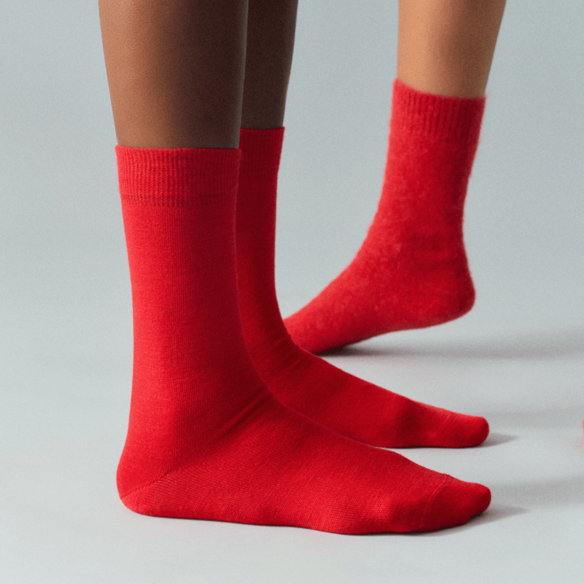 Red socks worn by a person on a gray background