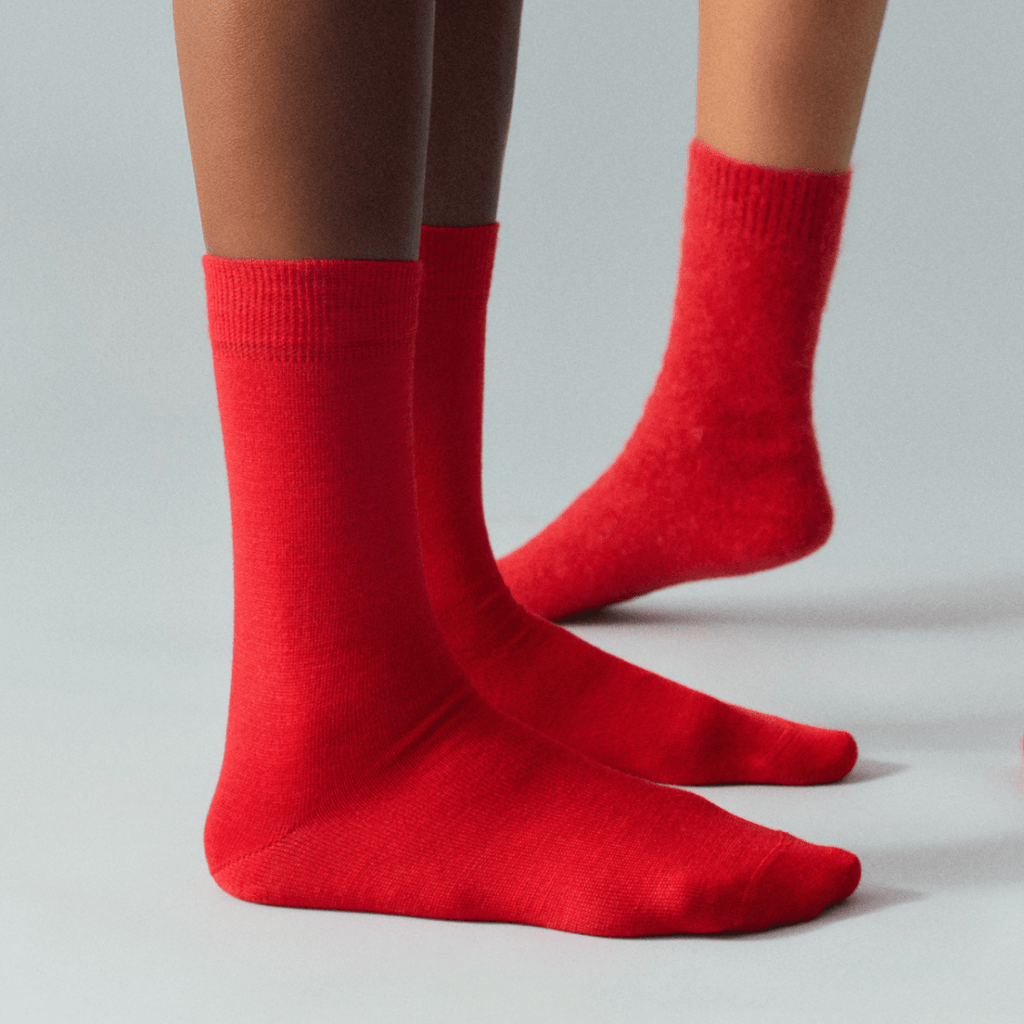 Red socks worn by a person on a gray background