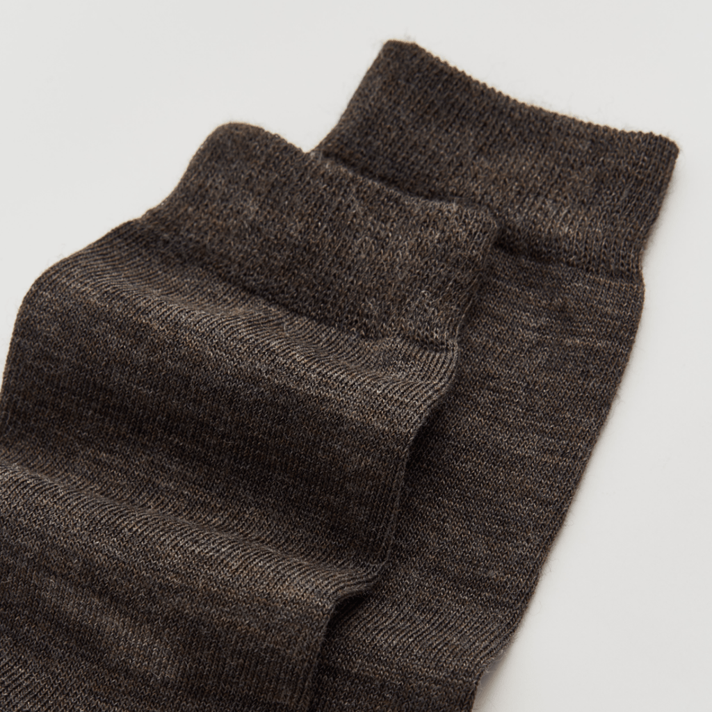 Pair of dark brown socks on a light gray background