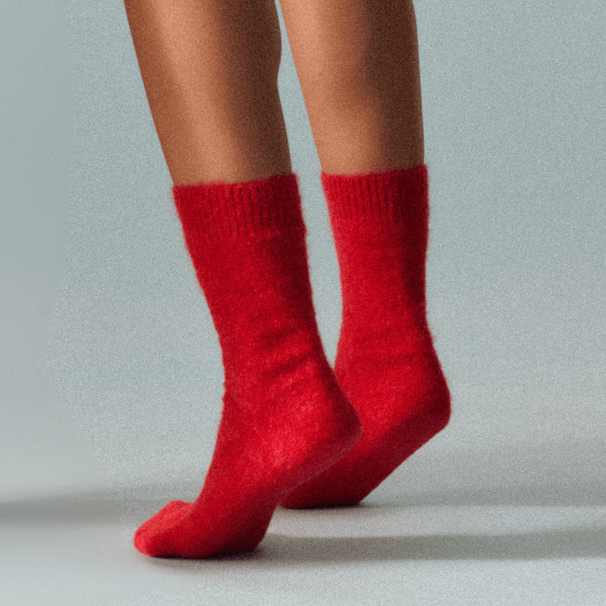 Red socks worn by a person on a light gray background