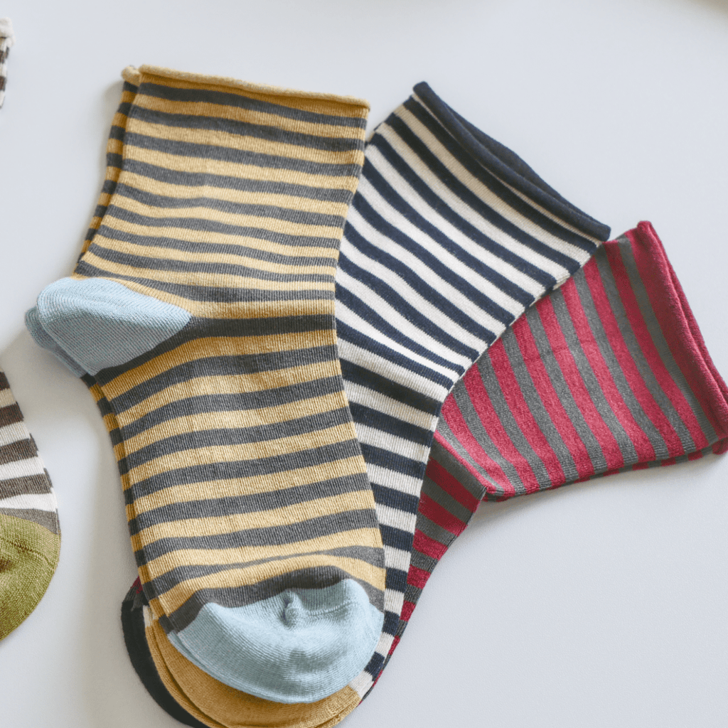 Set of colorful striped socks on a light surface sold by Helen Round