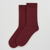 Pair of maroon socks on a light gray background