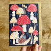 Card with cartoon mushrooms and a snail on a wooden surface