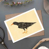 Greeting card with a bird illustration on a gray surface with decorative items.