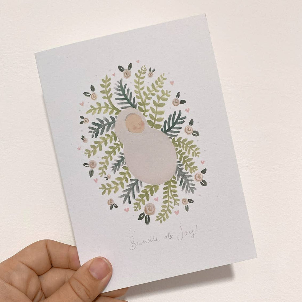 Hand holding a card with a bird and floral design on a light background  sold by Helen Round