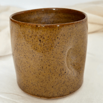 Brown ceramic cup on a light beige fabric background sold by Helen Round