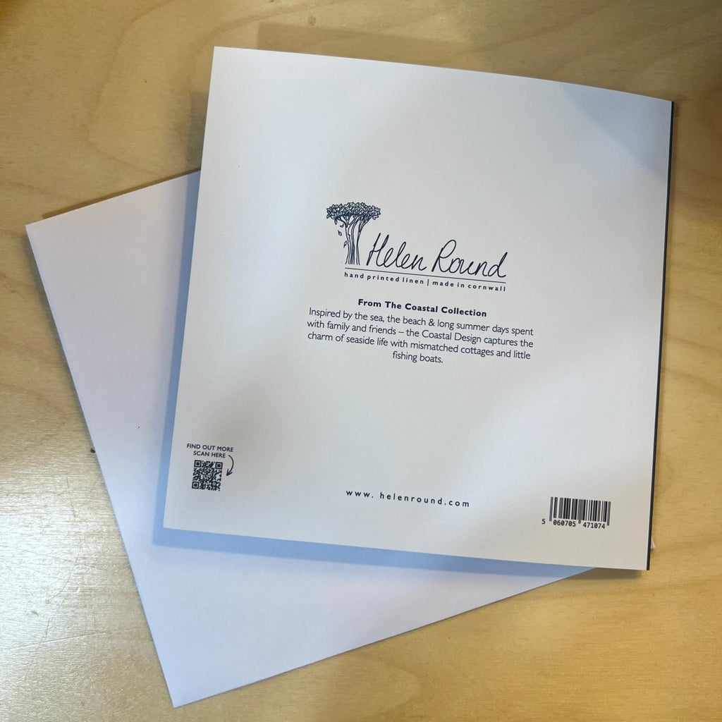 Back cover of a greetings card with branding on a wooden surface