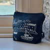 Navy blue linen makeup bag with white boat and building design on a windowsill.