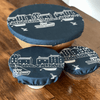 Set of three blue linen bowl covers with white designs on a wooden surface from Helen Round.