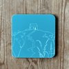 Tuquoise blue coaster with white Rame Head design on a wooden surface from Helen Round.