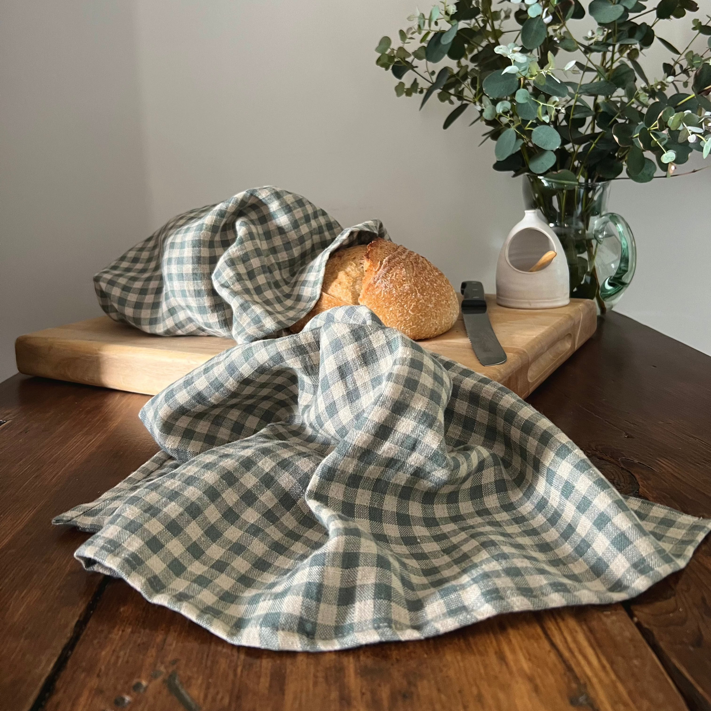 Sea Green Check Linen Tea Towel, pictured with Linen Bread Bag and sourdough bread from the Check Collection by Helen Round