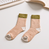 Pair of striped socks on a desk with a keyboard and book in the background sold by Helen Round