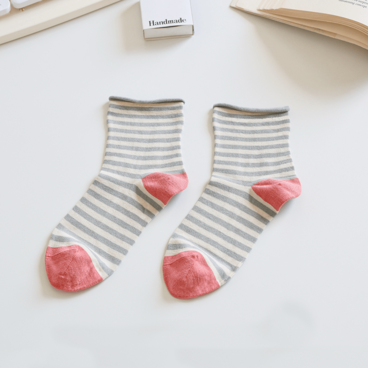 Pair of striped socks with pink toes on a light surface sold by Helen Round