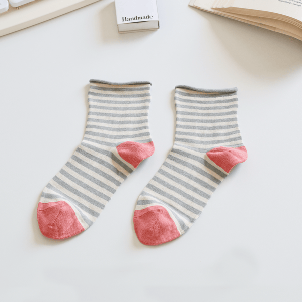 Pair of striped socks with pink toes on a light surface sold by Helen Round
