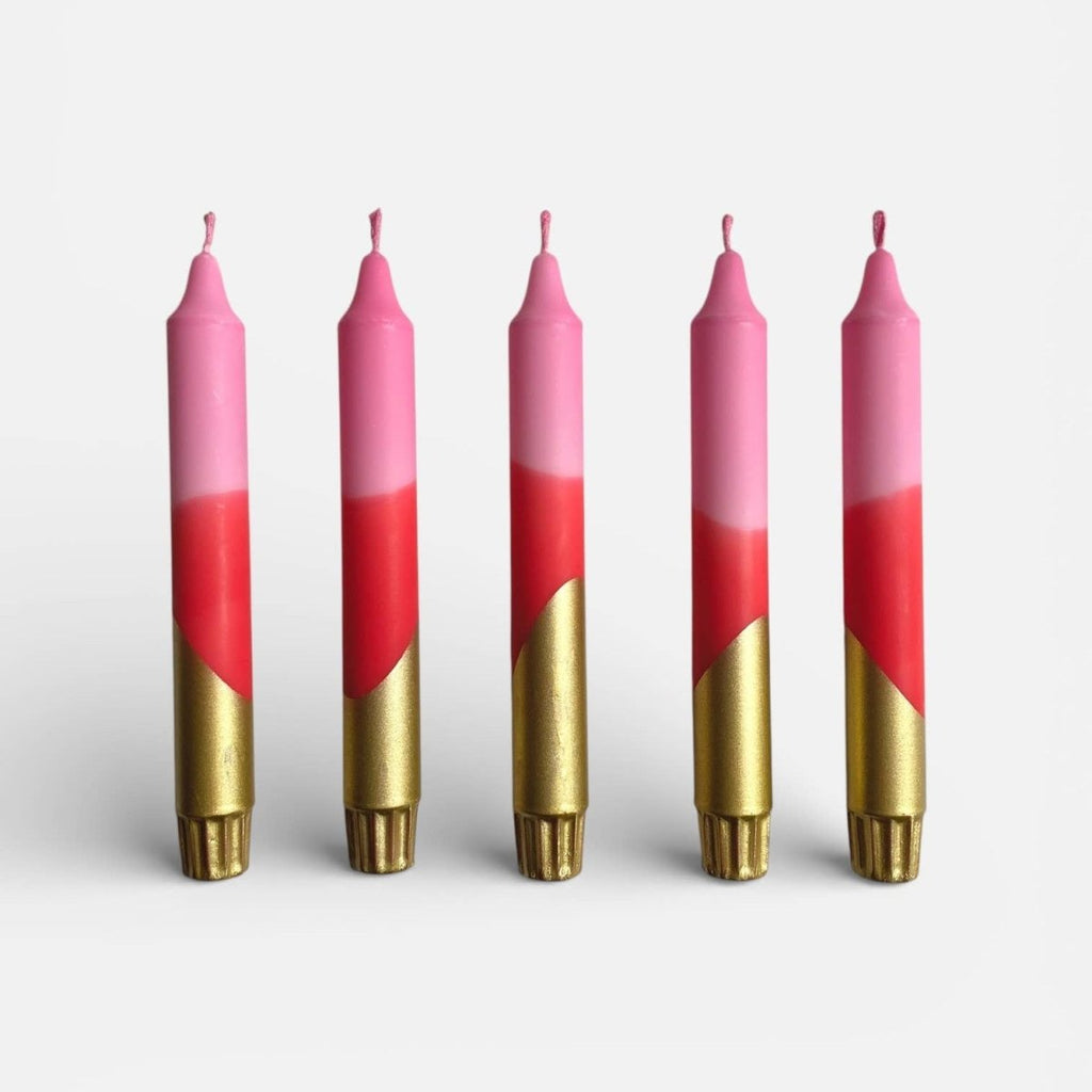 Five candles with pink and gold gradient design on a white background