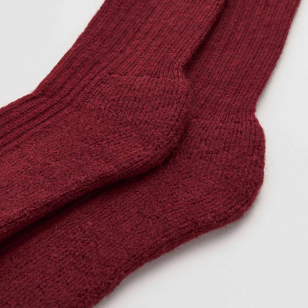 Close-up of a pair of maroon socks on a light gray background
