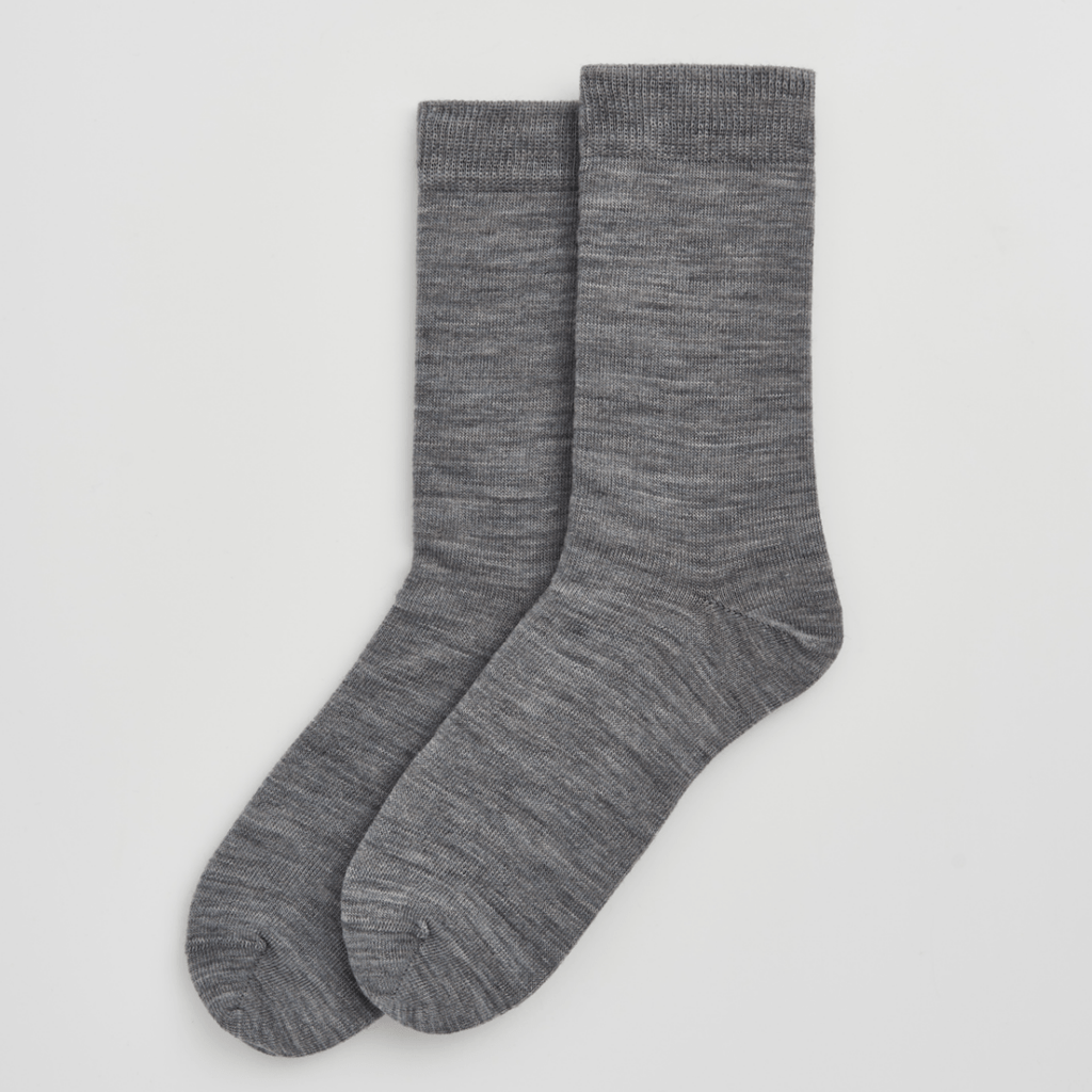 Pair of grey merino socks on a light grey background
