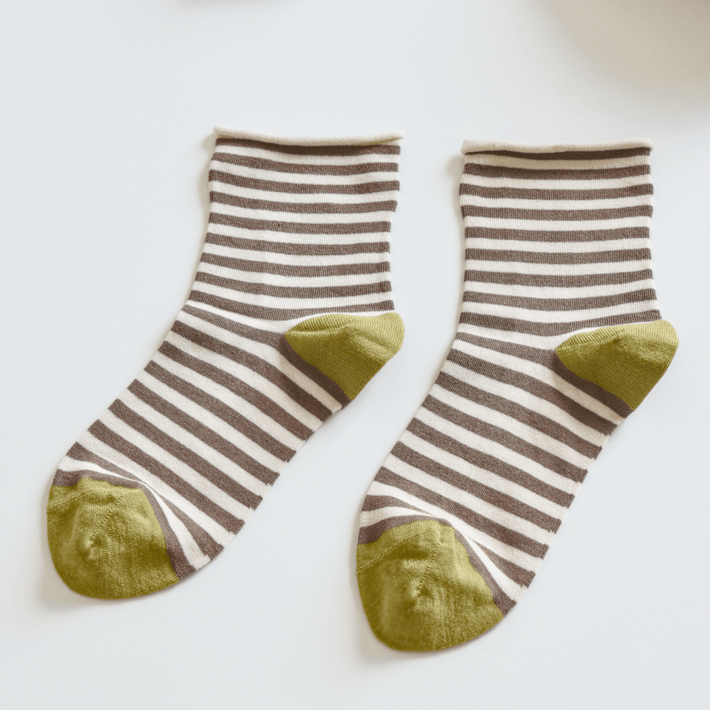 Pair of striped socks with green toes on a light surface sold by Helen Round