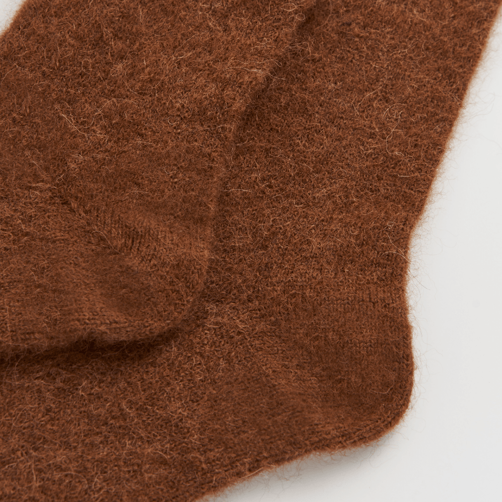 Brown knitted socks on a light gray background