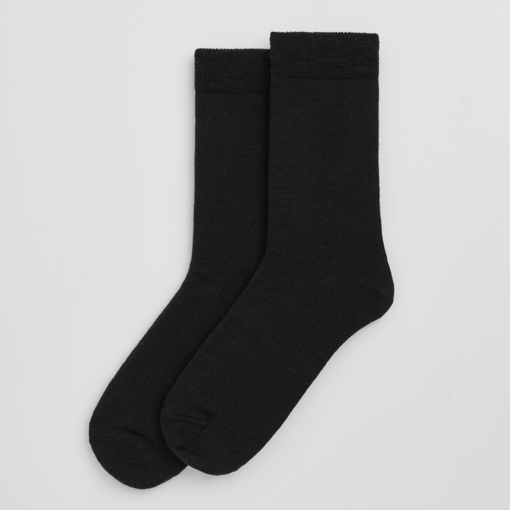 Pair of black merino wool socks on a light grey background