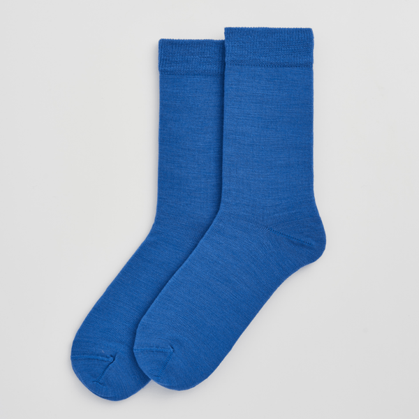 Pair of blue socks on a light gray background