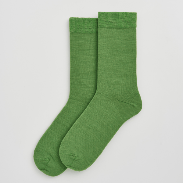 Pair of green socks on a light gray background