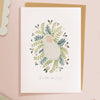 Framed artwork of a wreath with a baby illustration on a pink background  sold by Helen Round