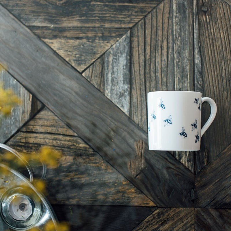 Small white bone china bee mug with bee design and white handle from the Honey Bee Collection by Helen Round. Dishwasher safe