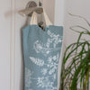 Close up of Linen Draught Excluder in Duck Egg Blue with a floral design in soft white from the Garden Collection by Helen Round