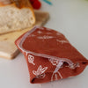 Rust-Coloured Linen Sandwich Wrap with Leaf Design from the Leaf Collection by Helen Round