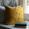 Mustard Linen Bee Cushion on window sill with books from the Honey Bee Collection by Helen Round