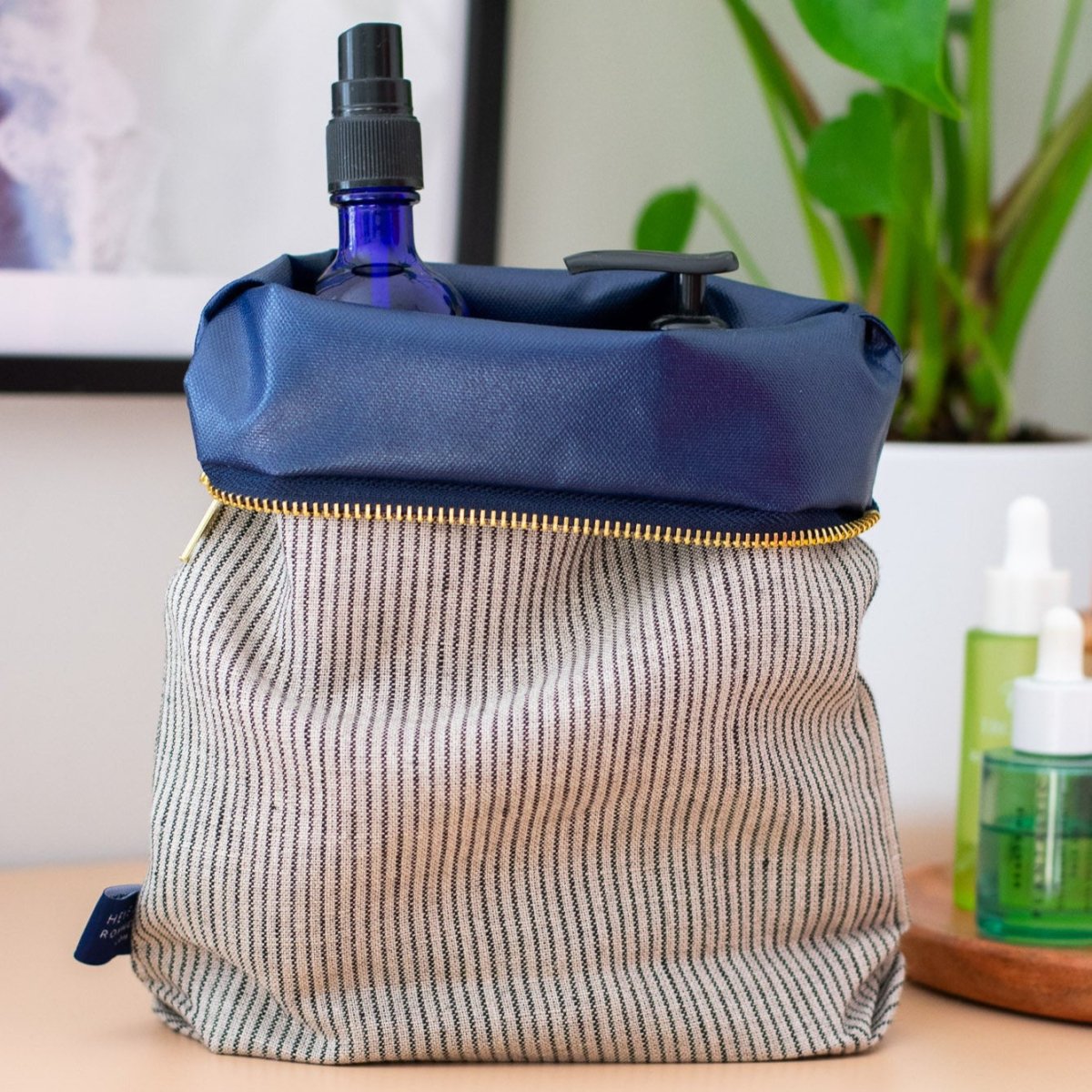 Striped Linen Toiletry Bag with top turned down to show splash proof lining and brass zip by Helen Round