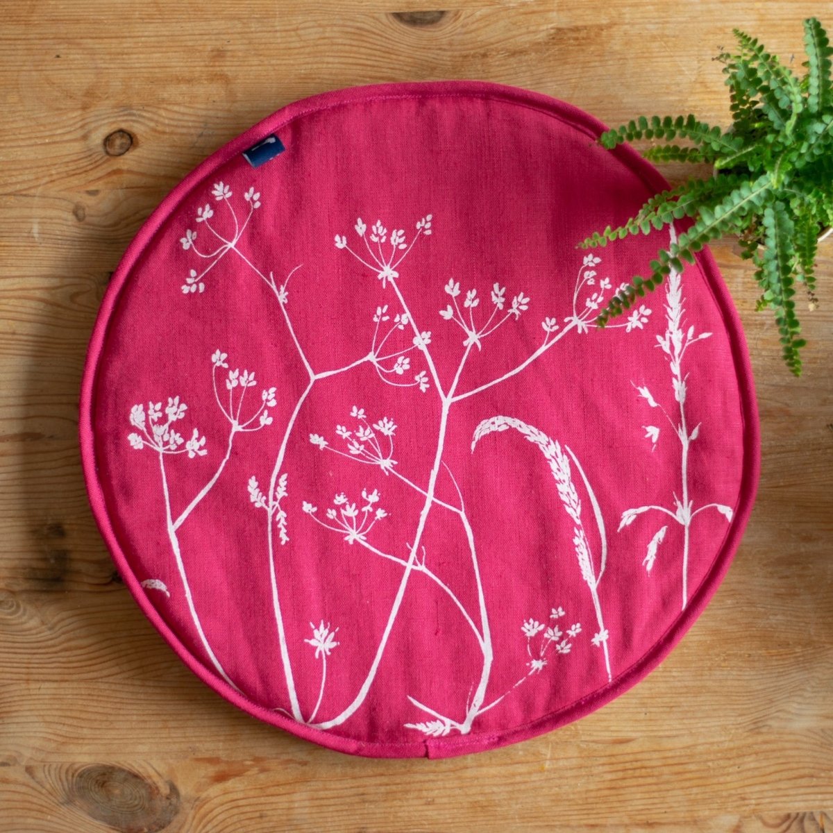 Aga pad with hedgerow grass design in raspberry red linen